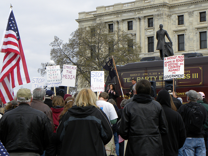 A photo of a crowd of people standing in front of the Tea Party Express Bus outside of the state capitol building for a rally