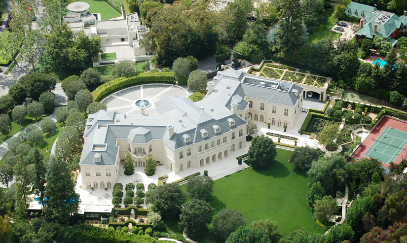 Bird's eye view of a palatial house with a beautifully manicured lawn.