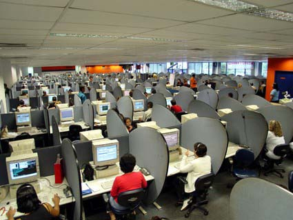 Many people at workstations in a call center are shown here.