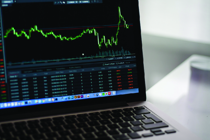 Picture of a laptop with a screen showing a chart of stock prices over time.